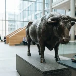 Bronze ox sculpture on a granite plinth, with a card terminal and smartphone on a slate cashier counter