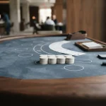 Blackjack cards and casino chips arranged on a dark table with a smartphone and hardware wallet in soft daylight