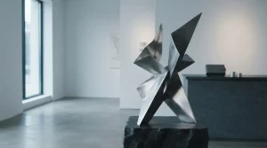 A sculptural metal installation in a daylight gallery with a discreet hardware wallet on a slate side table