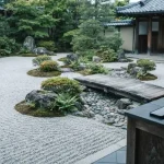 Raked Zen garden with river stones and a footbridge, with a smartphone and coins on a counter
