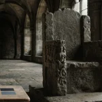 Weathered stone throne in a medieval hall with an understated payment counter and a phone in cool daylight