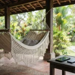 Woven cotton hammock on a shaded veranda, with a smartphone and hardware wallet on a small side table