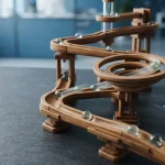 Wooden marble run with glass marbles rolling down chutes, with a smartphone and payment cards beside a cashier tray