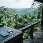 Sunlit tropical jungle canopy with dense foliage, a discreet phone and metal coins on a stone counter in the foreground